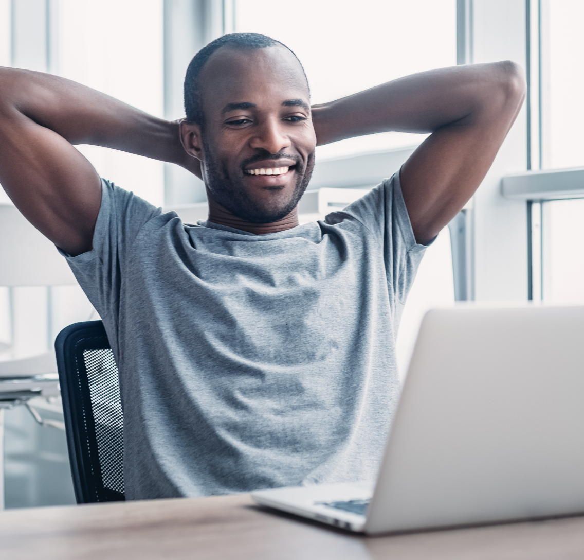 A male clinical development professional relaxing in front of his laptop after completing the digital design of a modern clinical trial